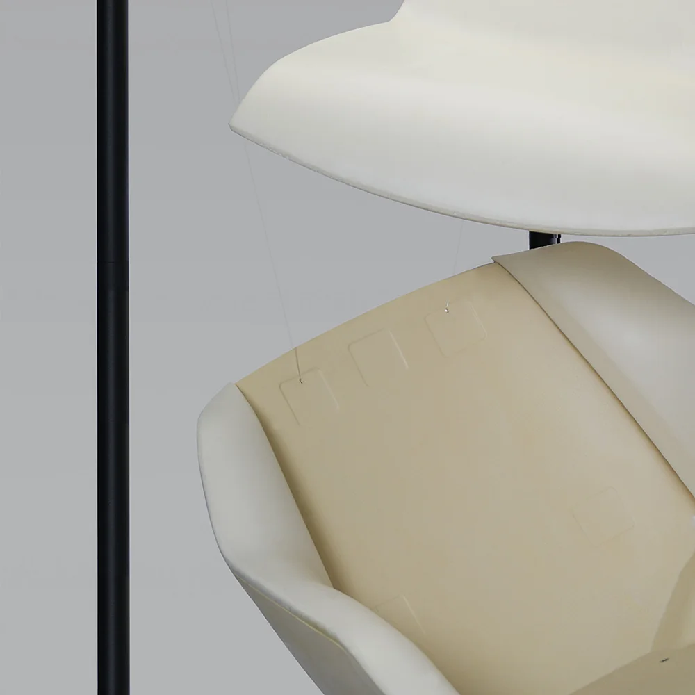 Close-up of suspended Terra Lounge chair components, showing the outer shell and inner foam layer within the display frame.