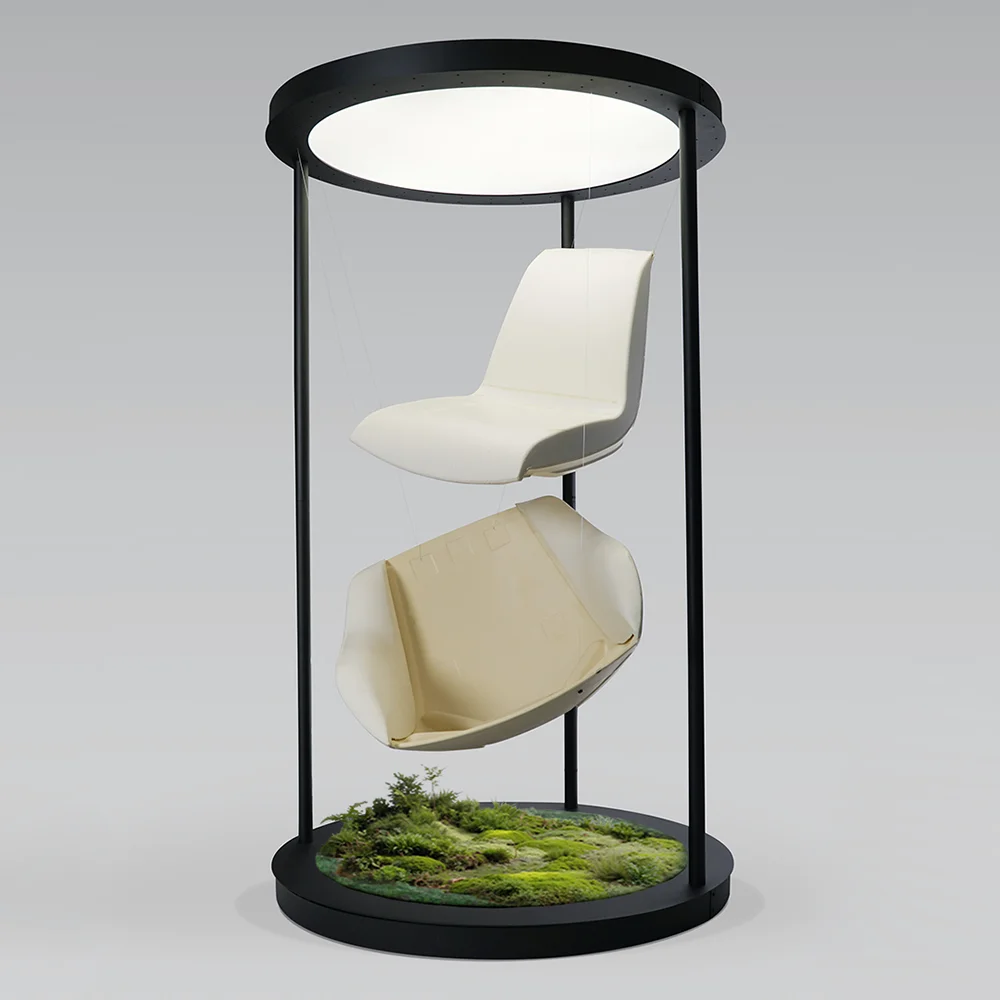 Terra Lounge chair components suspended within a circular display frame, with moss and greenery at the base, revealing the outer shell and inner foam construction.