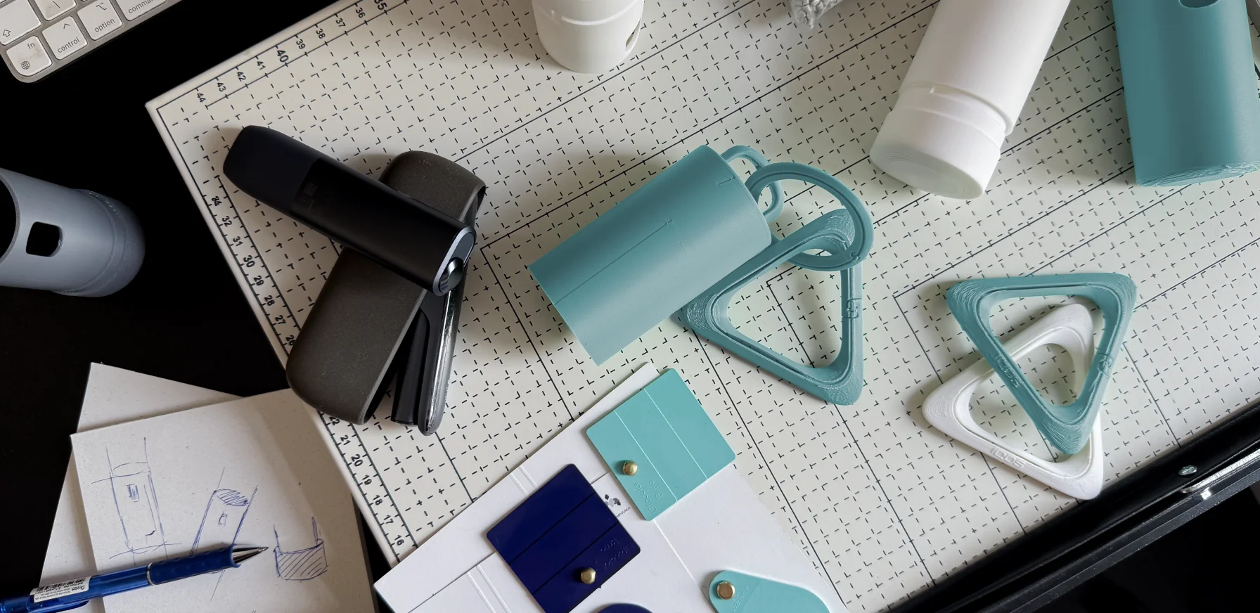 IQOS Clip Case prototypes, 3D printed carabiners and colour samples shown during the product design development process.