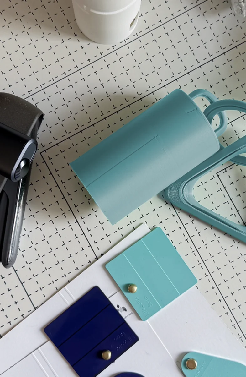 IQOS Clip Case prototypes, 3D printed carabiners and colour samples shown during the product design development process.