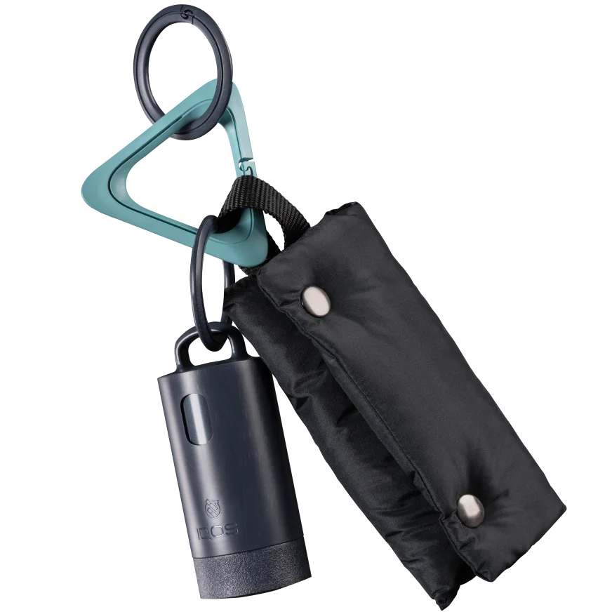 IQOS Clip Case attached to a black pouch using its Anthracite ring and IQOS Turquoise carabiner.