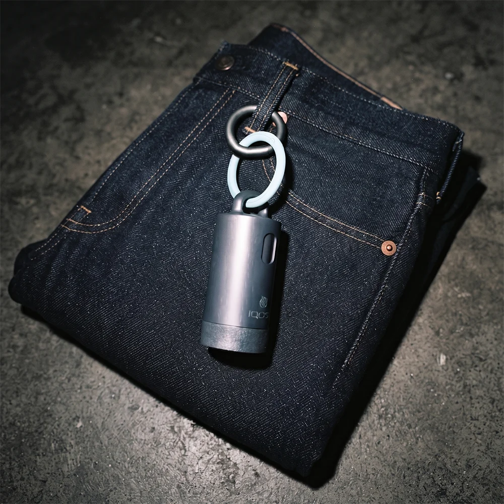 IQOS Clip Case attached to a pair of dark denim jeans using its Anthracite and turquoise rings.